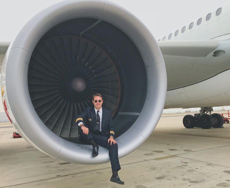 Pelican Flight School graduate posing in a jet engine turbine.